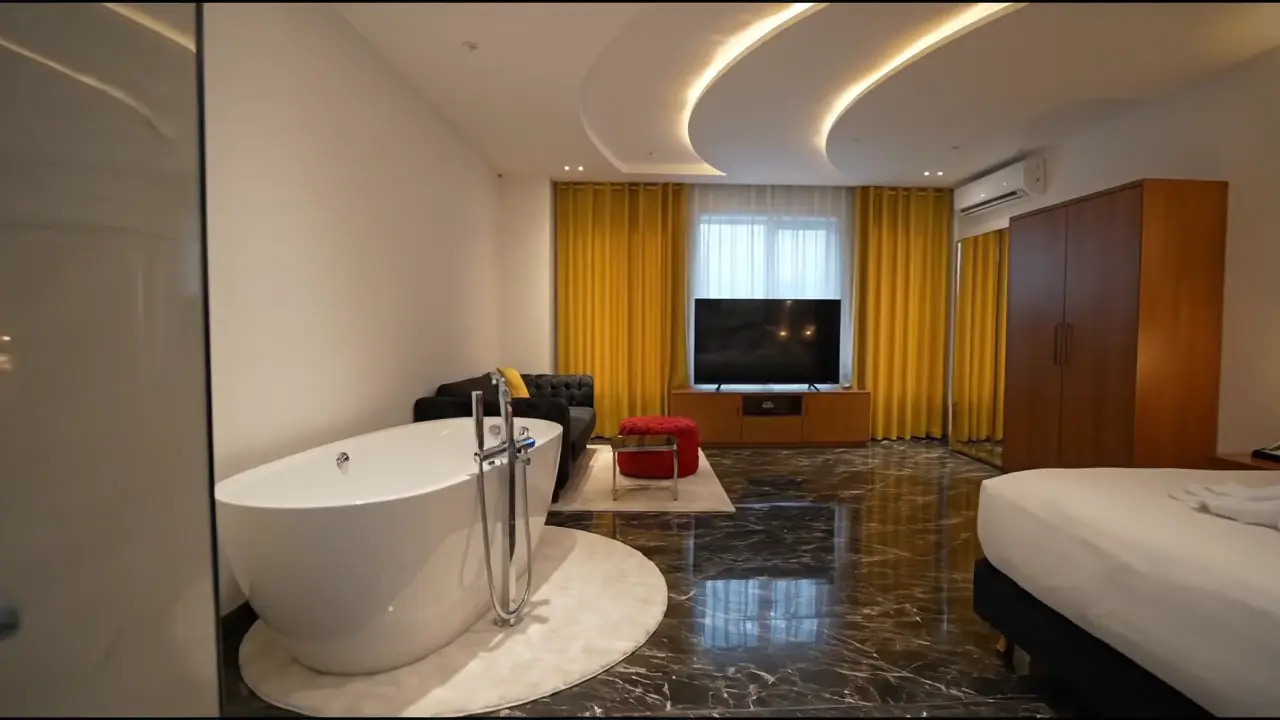 Visite de la Suite Velours : baignoire sur pied, grand lit et sol en marbre