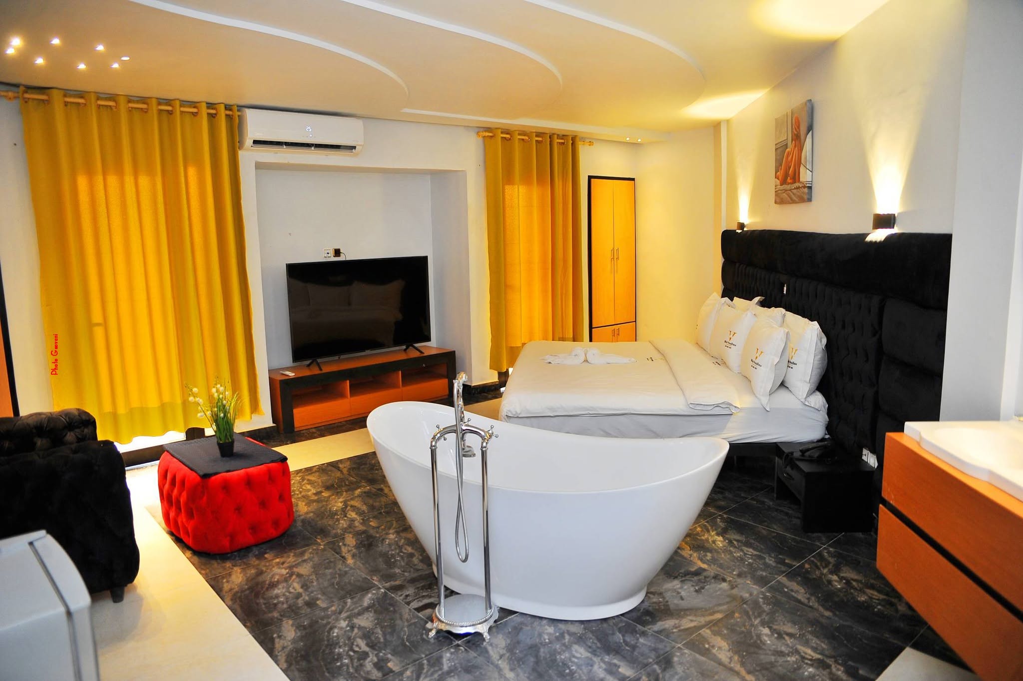 Suite avec baignoire sur pied, grand lit et coin salon
